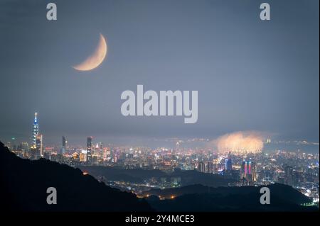 Ein atemberaubender nächtlicher Blick auf die Skyline von Taipei City mit Feuerwerk und einem Halbmond auf dem Qixi Festival. Die romantische Atmosphäre wird durch die Cels verstärkt Stockfoto