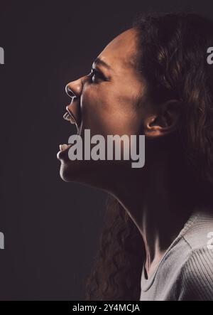 Frau, Angst und Depression beim Weinen um Hilfe, Angst und Schrei nach geistiger Gesundheit auf dunklem Hintergrund. Weibliche Person, bipolare Störung und traurig Stockfoto