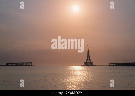 Die majestätische Silhouette der Tamsui-Brücke im Bau ist in den goldenen Tönen des Sonnenuntergangs getaucht. Die unvollendete Struktur steht hoch gegen ein V Stockfoto