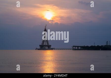 Die majestätische Silhouette der Tamsui-Brücke im Bau ist in den goldenen Tönen des Sonnenuntergangs getaucht. Die unvollendete Struktur steht hoch gegen ein V Stockfoto