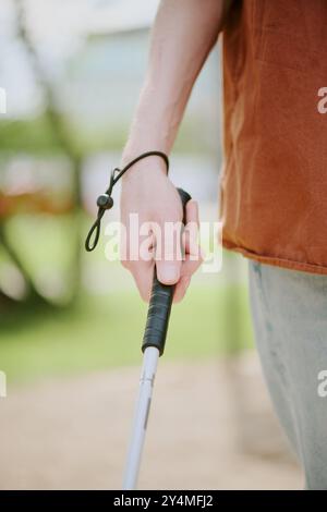 Vertikale mittlere Nahaufnahme einer nicht erkennbaren männlichen Hand, die Metallstock hält, um in den Park zu gehen Stockfoto