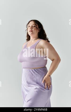 Eine schöne Frau in Übergröße zeigt ihr Selbstvertrauen und ihren Stil in einem schicken Lavendelensemble. Stockfoto
