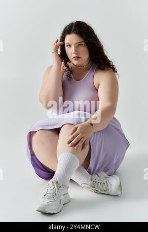 Eine schöne Frau in Übergröße zeigt ihr Selbstvertrauen und ihre Eleganz in weichen Pastelltönen. Stockfoto