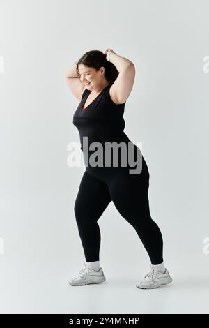 Mit einem fröhlichen Ausdruck zeigt eine schöne Frau in Übergröße ihre Eleganz und ihr Selbstvertrauen. Stockfoto