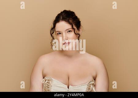 Eine atemberaubende Frau in Übergröße mit lockigen Haaren zeigt ihre Schönheit in einer ruhigen Umgebung. Stockfoto