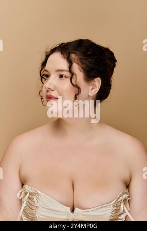 Eine schöne Frau in Übergröße zeigt ihre Eleganz mit weichen Locken und einem ruhigen Ausdruck. Stockfoto