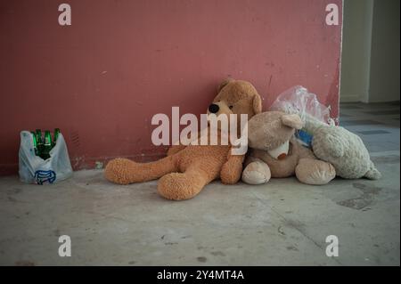 27.06.2016, Singapur, Republik Singapur, Asien - ausgeworfene gefüllte Teddybären liegen auf dem Boden neben leeren Bierflaschen in einem HDB-Wohnblock. Stockfoto