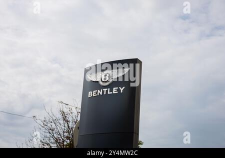 Minsk, Weißrussland, 19. September 2024 - Bentley-Zeichen und Logo auf dem Himmelhintergrund. Britischer Luxushersteller von Luxusautos Stockfoto