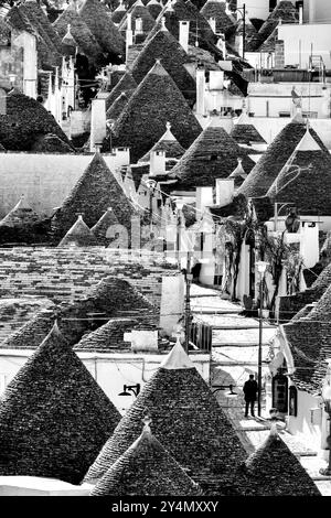 Ein schwarz-weißer Blick aus der Luft auf die Haupteinkaufsstraße zwischen den Trulli-Häusern in Rione Monti, Alberobello, Italien. Stockfoto