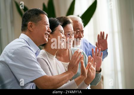 Gruppe glücklicher älterer asiatischer Menschen, zwei Paare, die Hände winken und Freunde oder Familie während des Videochat begrüßen Stockfoto