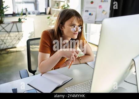 Konzentrierte Einzelpersonen setzen sich mit ihrem Computer auseinander, machen Notizen und Ideen. Stockfoto