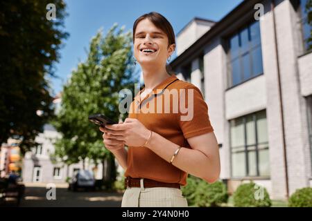 Eine freudige, nicht binäre Person greift in einem Büro im Freien an ihr Telefon. Stockfoto