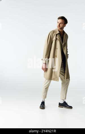 Ein Dandy in einem schicken Trenchcoat zeigt moderne Mode mit Selbstbewusstsein und Flair. Stockfoto