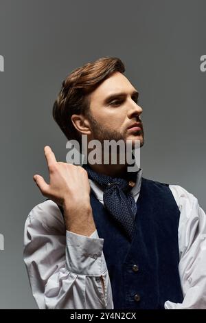 Ein hübscher Dandy zeigt seinen einzigartigen Stil und besticht durch eine nachdenkliche Pose in eleganter Kleidung. Stockfoto