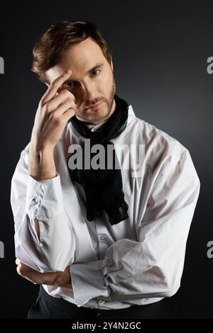 Ein hübscher junger Mann mit stilvollem Dandy-Look reflektiert nachdenklich und elegant gekleidet. Stockfoto