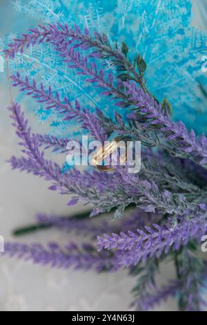 Nahaufnahme von zwei Eheringen auf einer künstlichen Blume. Weichzeichner Stockfoto