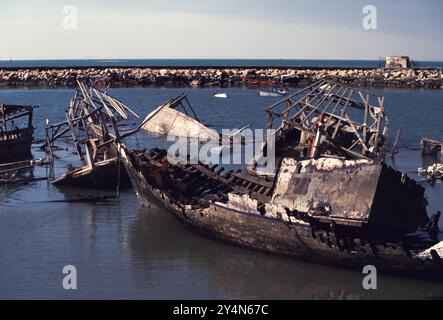 Am 8. März 1991 wurde Kuwaits zerstörte Dau-Flotte von der irakischen Armee verbrannt und befindet sich im Hafen der alten Schiffe in Kuwait City. Die hölzernen Fischerboote sind Kuwaits nationales Symbol. Stockfoto