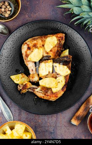 Gebratene Hähnchenschenkel mit Ananasstücken. Gebratenes Hähnchenfleisch. Draufsicht. Stockfoto