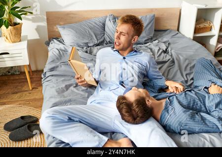 Zwei Partner teilen sich einen ruhigen Morgen, in Pyjamas gehüllt, und lesen und genießen sich gegenseitig in Gesellschaft. Stockfoto