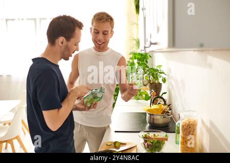 Ein liebevolles Paar teilt einen wunderbaren Moment, während sie Gemüse hacken und in ihrer Küche einen lebendigen Salat zubereiten. Stockfoto