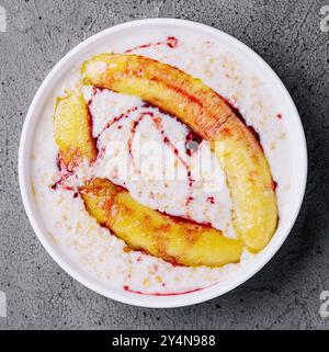 Haferflocken mit gebratener Banane auf Stein Stockfoto