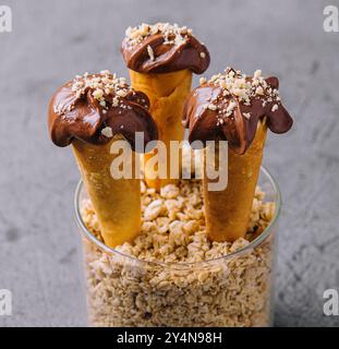 Waffelkegel mit Haselnüssen und Schokoladencreme Stockfoto