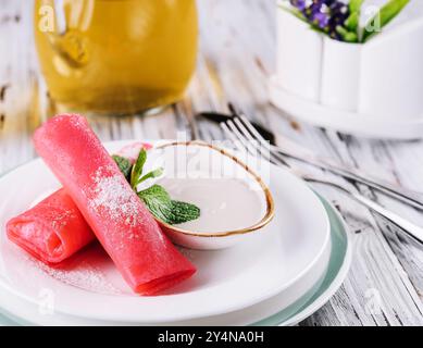 Gerollte Himbeerpfannkuchen mit Sauerrahm für Kinder Stockfoto