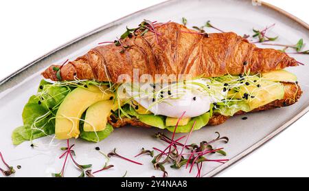 Croissant benedict Lachs mit pochiertem Ei, serviert mit frischem Salat Stockfoto