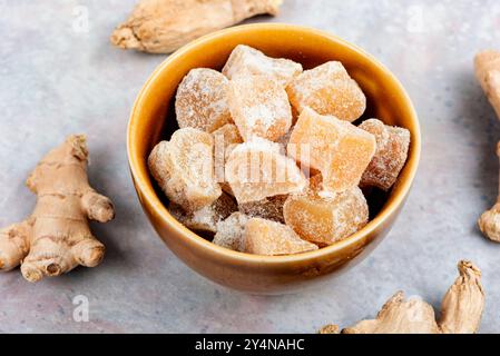 Schüssel mit kandierten Ingwerstücken und Ingwerwurzeln, kandiertes Ingwerdessert. Stockfoto