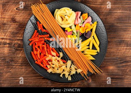 Ein Set trockener Makkaroni, rohe Nudeln und Spaghetti auf rustikalem Holztisch. Stockfoto