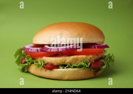 Köstlicher veganer Burger mit Kichererbsenkotelett auf grünem Hintergrund Stockfoto