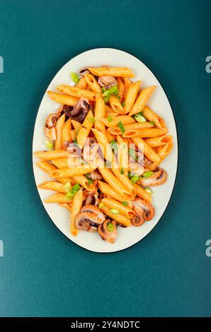 Makkaroni oder Pasta gekocht mit Tintenfisch in weißem Gericht. Makkaroni mit Meeresfrüchten. Italienisches Essen Stockfoto