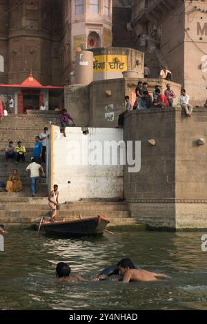 Varanasi, Uttar Pradesh / Indien - 9. Mai 2015 : die Menschen sitzen auf einer großen Säule in der Nähe von Darbhanga Ghat und schwimmen im Fluss Gang Stockfoto