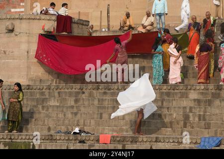 Varanasi, Uttar Pradesh / Indien - 9. Mai 2015 : Eine Gruppe von Pilgerinnen an der Küste von Varanasi ist damit beschäftigt, ihre Sarees in der Sonne zu trocknen. Stockfoto