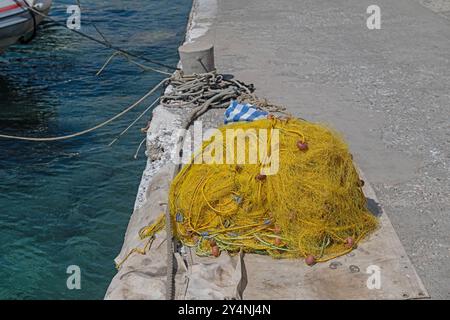 Gelbe Fischernetze in Haufen am Strand. Stockfoto