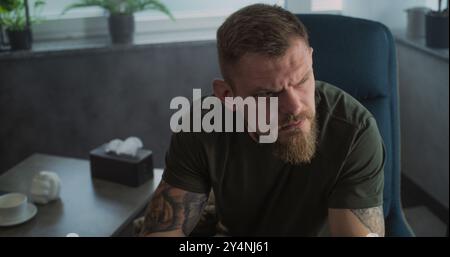 Männlicher Soldat spricht mit Psychotherapeuten oder Psychologen, teilt Gefühle. Porträt eines gestressten Militärs mit PTBS-Weinen während der Psychotherapiesitzung. Posttraumatische Belastungsstörung. Psychische Gesundheit. Stockfoto