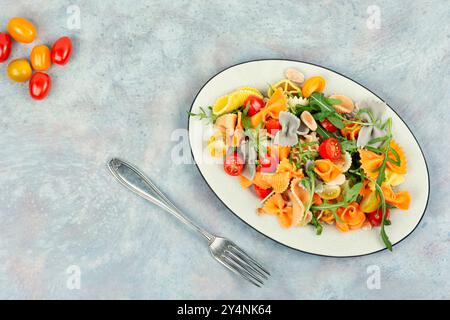 Eine Schüssel mit traditionellem Nudelsalat mit frischen Tomaten und Kräutern. Leerzeichen für Text. Stockfoto
