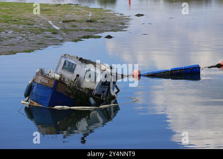 Gosport, Hampshire, England. 13. September 2024. Ein versunkenes kleines Boot in Haslar Creek. Von der Haslar-Brücke aus gesehen. Dieses Foto ist eines einer Serie, die ich kürzlich bei einem Besuch des Royal Navy Cemetery Haslar während der Gosport Heritage Open Days gemacht habe. In dieser Auswahl sind einige Fotos enthalten, die ich auf dem Weg zu und weg von der Veranstaltung gemacht habe, als ich zu Fuß war. Stockfoto