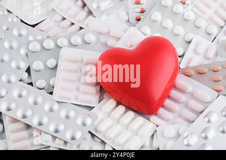 Rotes Herz auf einem großen Haufen von vielen verschiedenen Tabletten und Tablettenpackungen Stockfoto