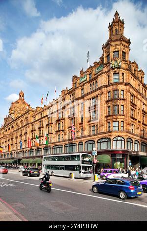 London, Großbritannien, 3. Mai 2009, das berühmte Harrods-Gebäude zeigt seine atemberaubende Architektur, während Doppeldeckerbusse und Autos auf einer geschäftigen Londoner Straße vorbeifahren Stockfoto