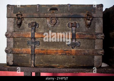 Alter spanischer Kofferraum aus Holz mit Metallverstärkungen und Beschlägen. Es hat ein rustikales Aussehen, mit Abnutzung. Historische Designelemente Stockfoto