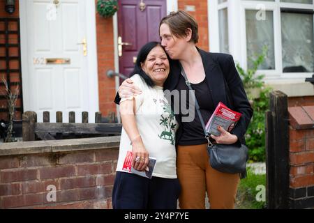 Der Labour-Abgeordnete Jess Phillips gibt einem ihrer Wähler Yasmin Richardson, 68, eine Umarmung und einen Kuss, während er in Birmingham Yardley, Jess Ph., vorführt Stockfoto