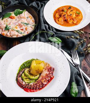 Oktopus Sizilianer, Lachs in Sahnesauce, Garnelen in Romesco-Sauce Stockfoto