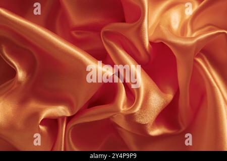 Hintergrund und Textur von Seidengewebe in Pfirsichfarbe Stockfoto