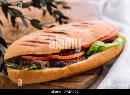 Sandwich mit Fleisch und Gemüse auf einem Holzbrett Stockfoto