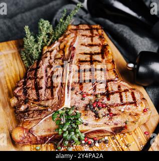 Ein großes gegrilltes Steak auf einem Holzteller Stockfoto