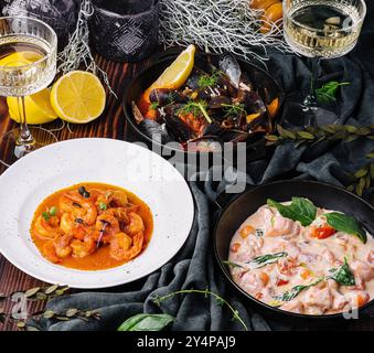 Lachs in Sahnesauce, Garnelen in Romesco-Sauce und Muscheln Stockfoto