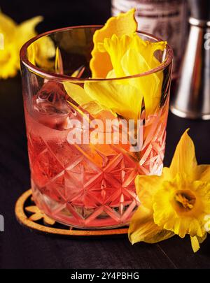 Glas negroni Cocktail dekoriert mit Blumen Stockfoto