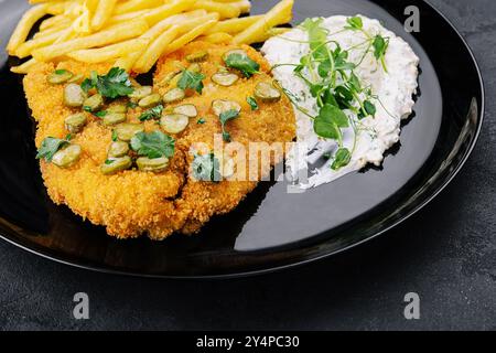 Köstliches wiener Jägerschnitzel mit Sauce und Pommes Frites in Nahaufnahme auf einem Teller Stockfoto
