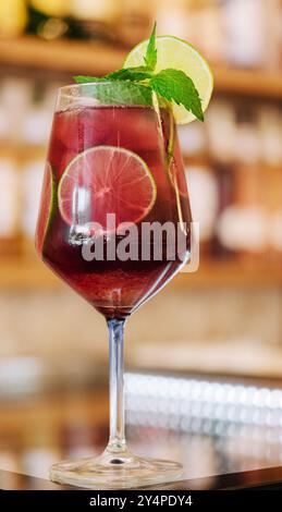 Kalter rosafarbener Cocktail mit frischer Grapefruit, Limette und Eiswürfeln auf dem Restauranttisch Stockfoto